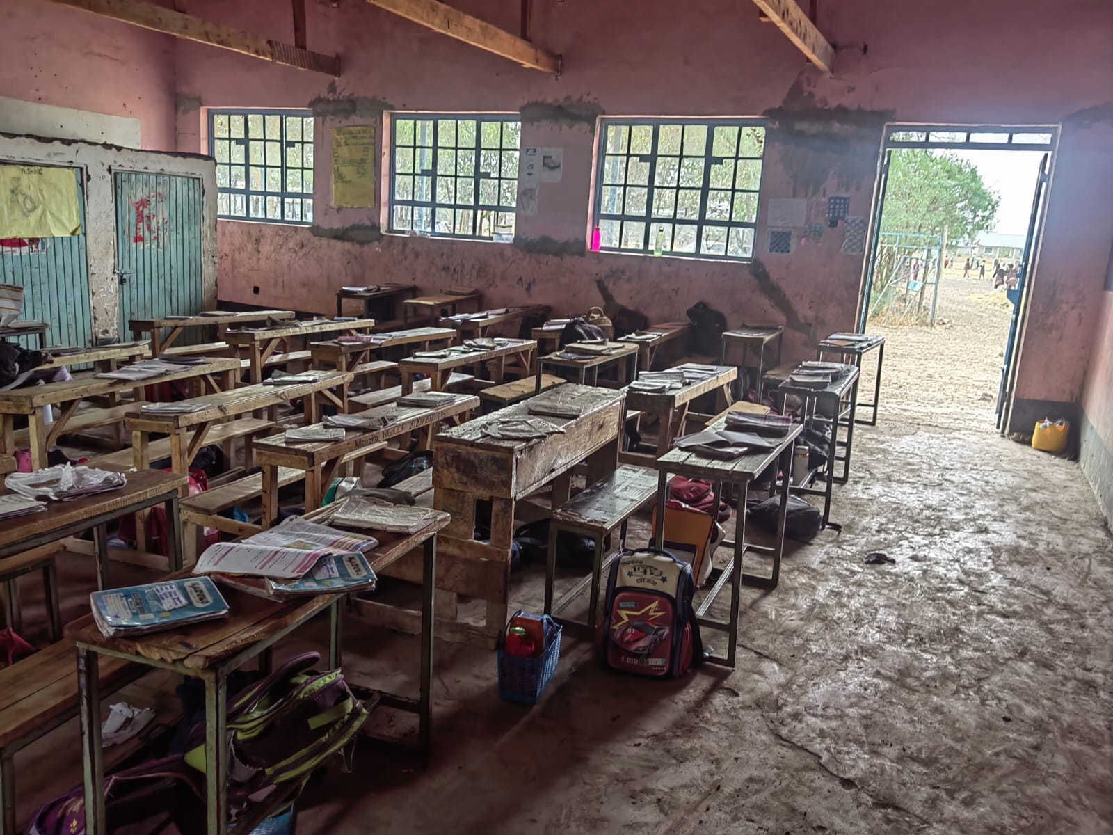 Rows of wooden desks in a brick classroom