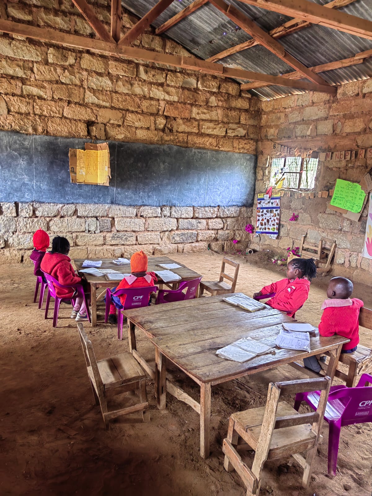 Learners and wooden desks inside a classroom