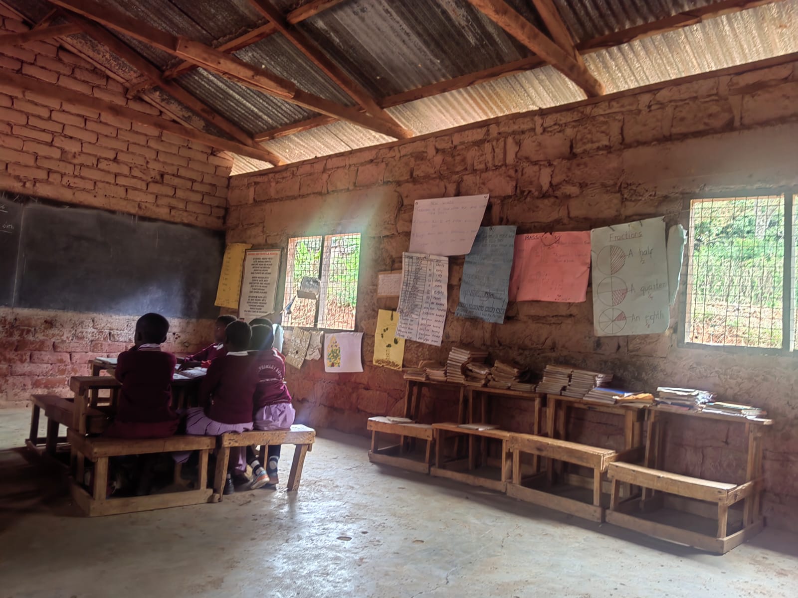 Learners seated in a classroom with exposed brick walls